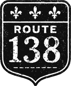 Logo documentaire Route 138. Une affiche routière noir et blanc, avec l'indication Route 138. Usée.