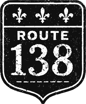 Logo documentaire Route 138. Une affiche routière noir et blanc, avec l'indication Route 138. Usée.
